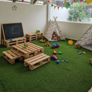 Césped artificial y palets con jardín infantil